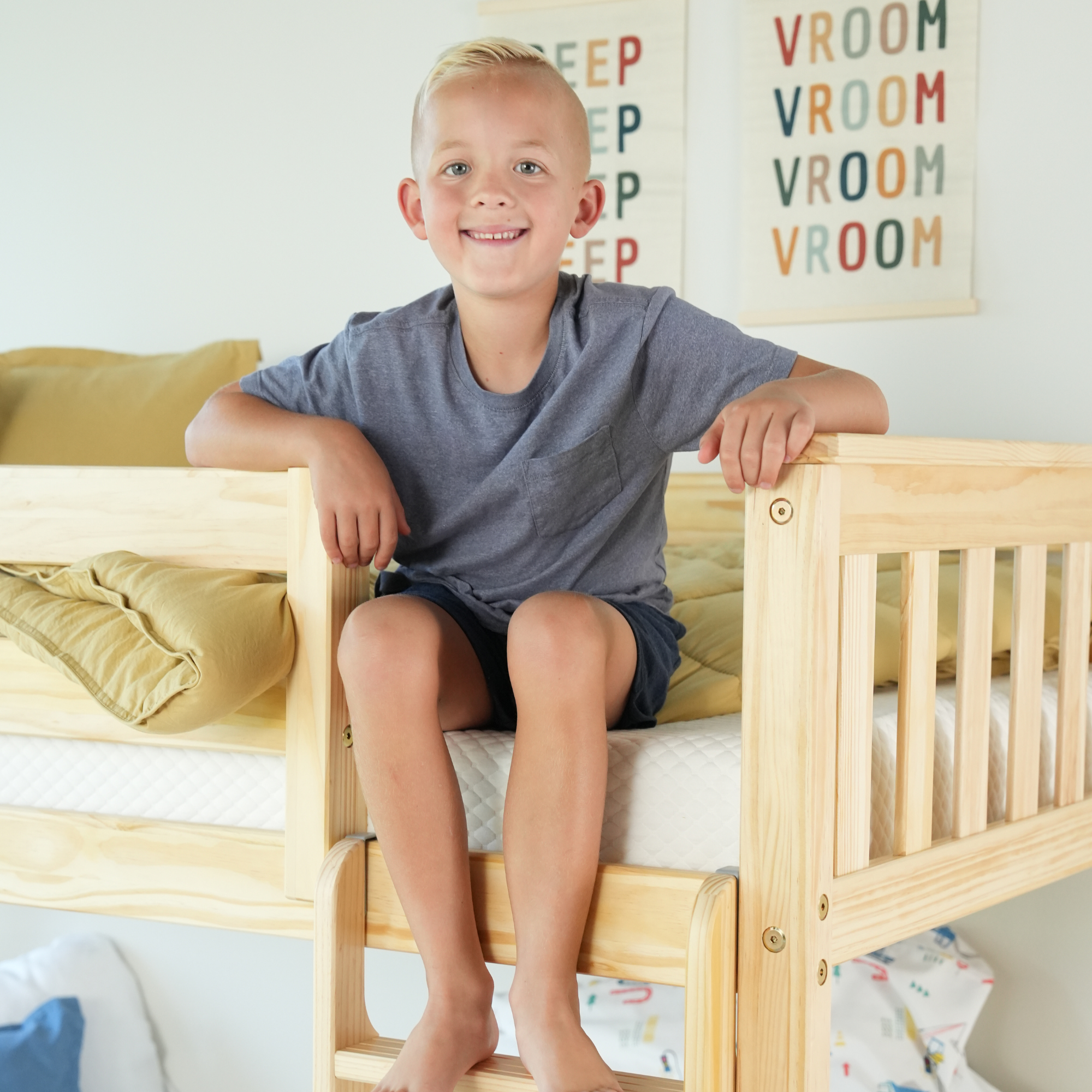 Child in green shirt and orange shorts lying on a textured white surface.