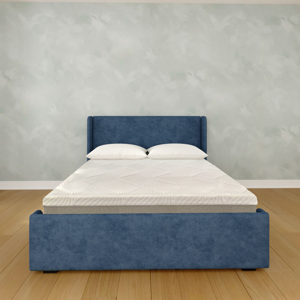 Modern bedroom with a stylish blue upholstered bed and comfortable mattress.