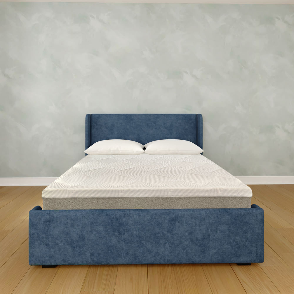 Elegant modern bedroom with a stylish blue upholstered bed frame and comfortable mattress on hardwood floor.