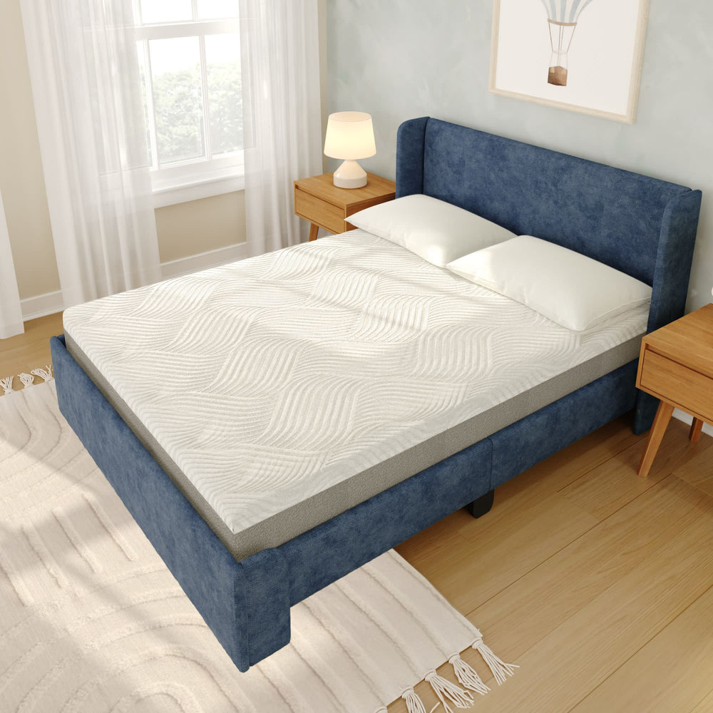 Blue upholstered bed with comfortable memory foam mattress and white bedding in a modern bedroom setting.