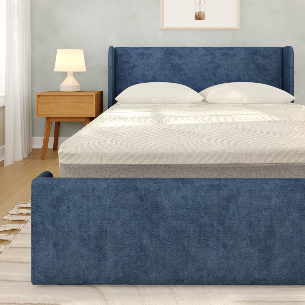 Elegant blue upholstered platform bed with modern headboard in a cozy bedroom setting featuring wooden nightstand and stylish lamp.