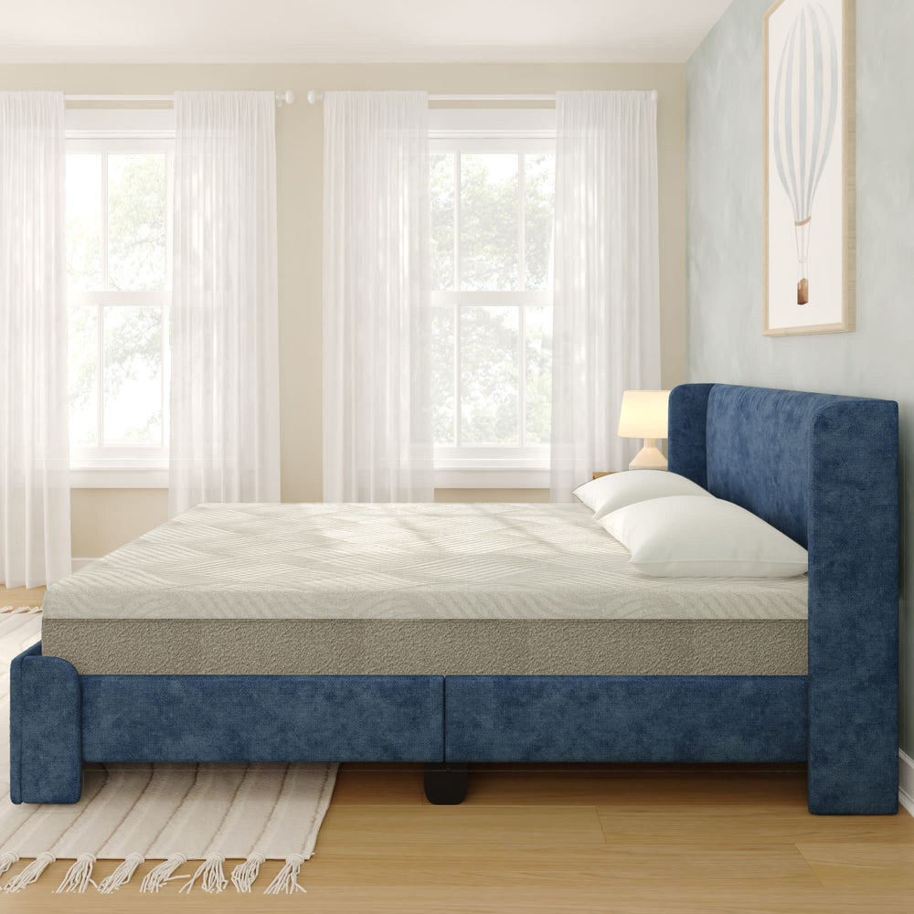 Elegant bedroom featuring a comfortable blue upholstered bed and soft lighting by windows with sheer curtains.
