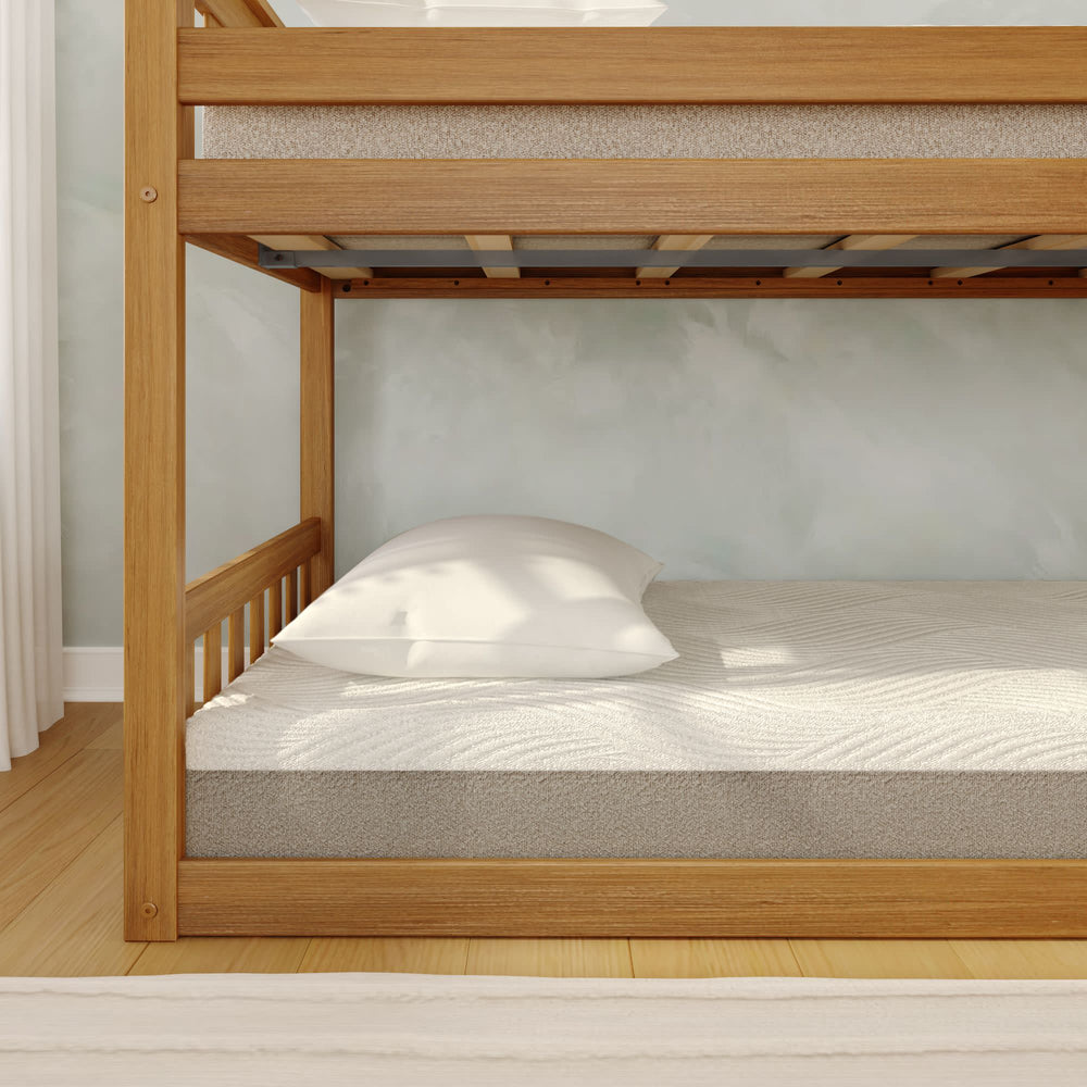 Wooden bunk bed with a comfortable mattress and white pillow in a bright, modern bedroom.