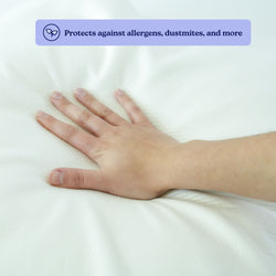 Hand pressing on an allergen-proof mattress cover, highlighting dust mite protection.