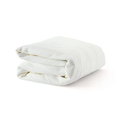 Folded white blanket made of soft, textured fabric on a clean background.