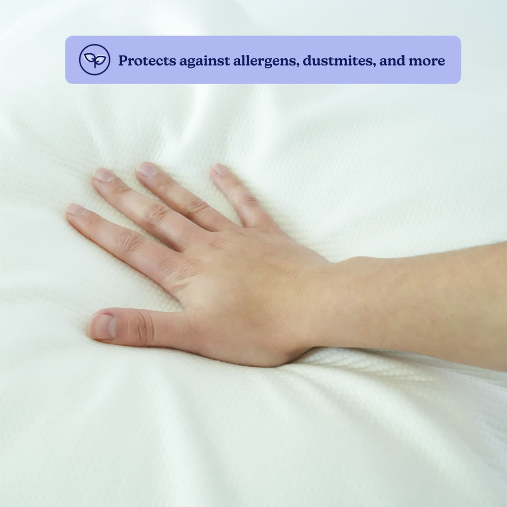 Hand pressing hypoallergenic pillow showcasing protection against allergens and dust mites.