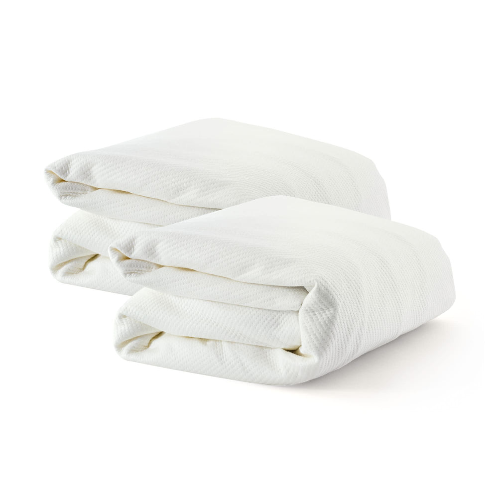 Folded white cotton bedsheets on a white background.