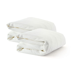 Folded white cotton bedsheets on a white background.