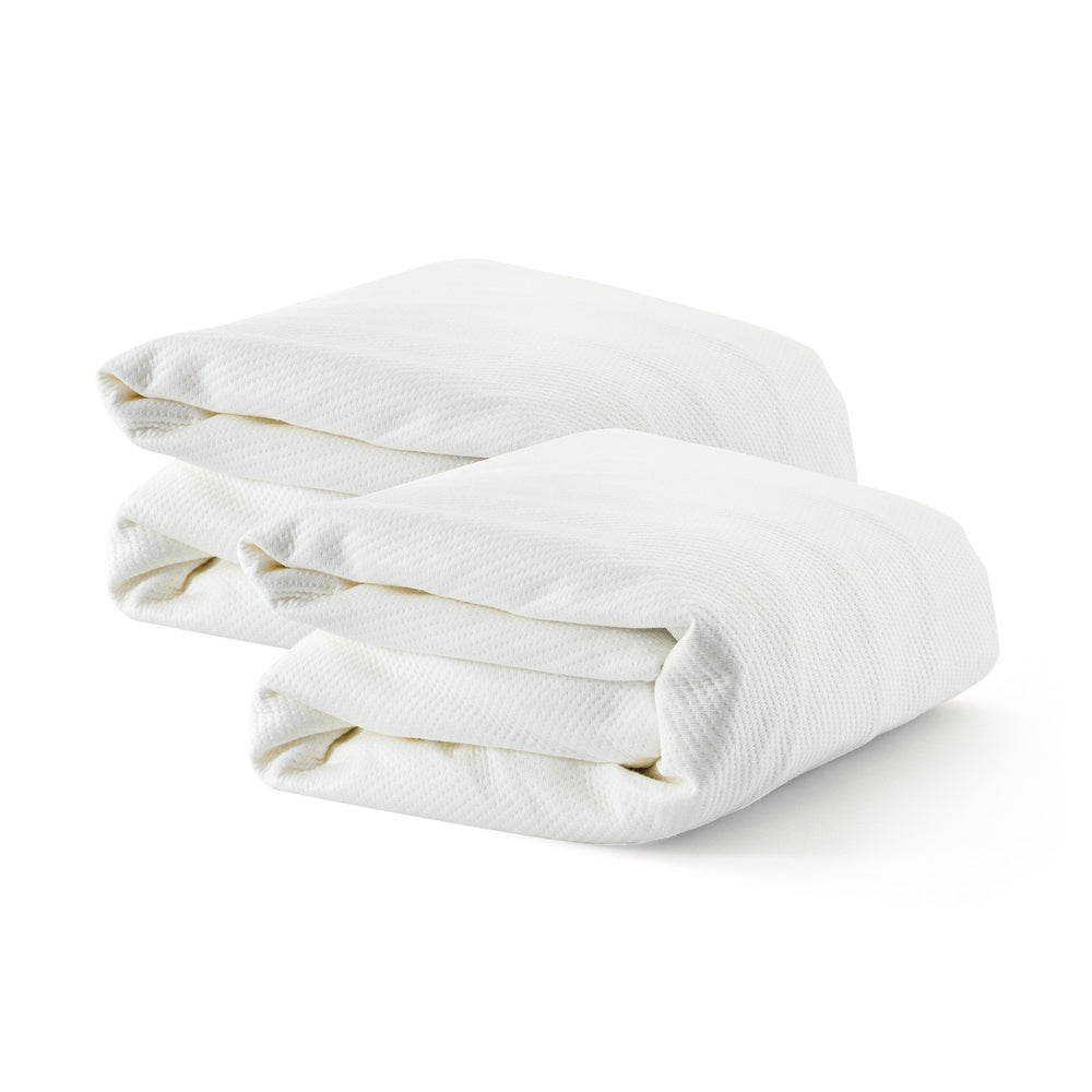 Two folded white knitted blankets on a white background.