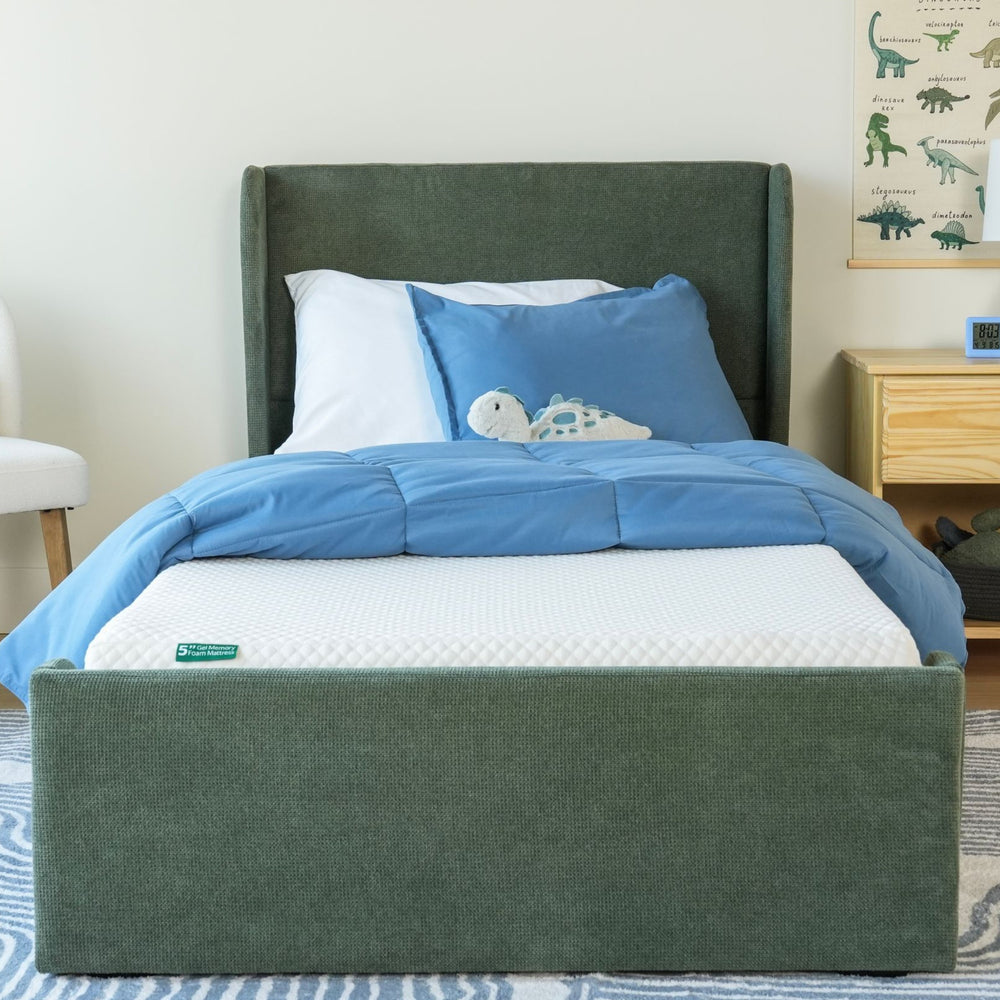 Comfortable children's bed with blue bedding and plush toy on a durable memory foam mattress.