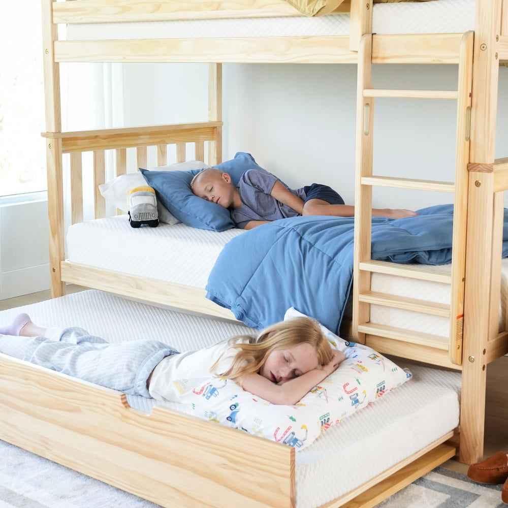 Children sleeping peacefully on wooden bunk beds with blue bedding in a bright, cozy bedroom.