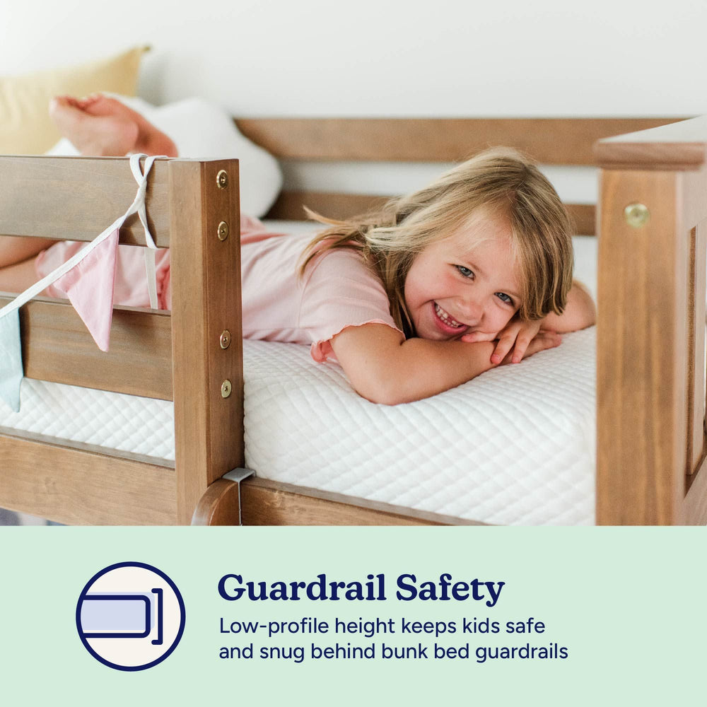 Child smiling on a safe bunk bed with guardrail, emphasizing guardrail safety for kids.